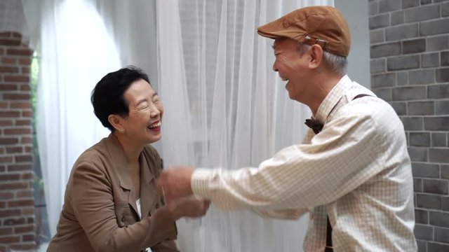 Asian senior elderly play laugh have fun together hide and seek behind net