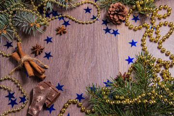Light wooden background with Christmas trees tinsel beads and New Year's decor