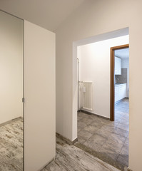 Empty white corridor with closet and tile