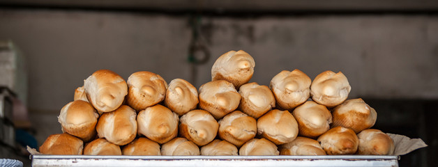 Breads and baked goods close-up. Bakery, baguette, bun, bread roll background. Heap of fresh bread...