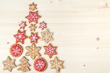 christmas tree made from homemade gingerbread cookies on wooden background with empty copy space for your text. holiday, celebration and cooking concept. new year and christmas postcard
