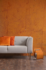 Wabi sabi living room interior with old orange wall and new stylish couch with pillows, real photo...
