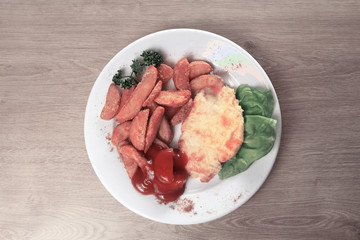 chicken in cheese and village-style potatoes with salad on plate
