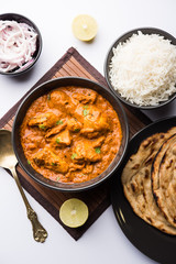 Murgh Makhani / Butter chicken tikka masala served with roti / Paratha and plain rice along with onion salad. selective focus