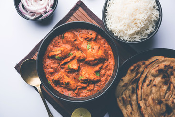 Murgh Makhani / Butter chicken tikka masala served with roti / Paratha and plain rice along with onion salad. selective focus