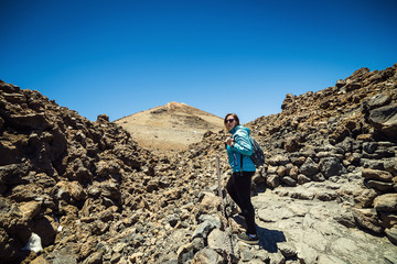 Fototapeta premium girl over the clouds on top of the mountain by the volcano Teide, Tenerife, Canary Island, Spain