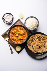 Murgh Makhani / Butter chicken tikka masala served with roti / Paratha and plain rice along with onion salad. selective focus