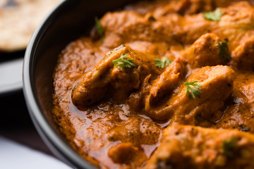 Murgh Makhani / Butter chicken tikka masala served with roti / Paratha and plain rice along with onion salad. selective focus