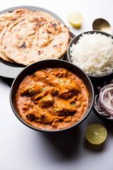 Murgh Makhani / Butter chicken tikka masala served with roti / Paratha and plain rice along with onion salad. selective focus