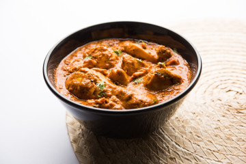 Murgh Makhani / Butter chicken tikka masala served with roti / Paratha and plain rice along with onion salad. selective focus