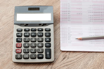 Calculator,  pencil, bankbook Put on a wooden table.