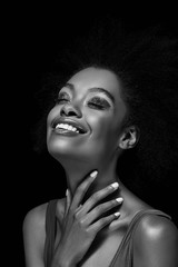 black and white photo of smiling african american woman isolated on black