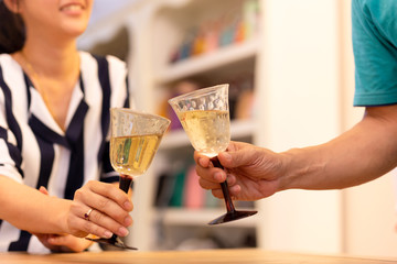 Couples celebrate with white wine in the house.