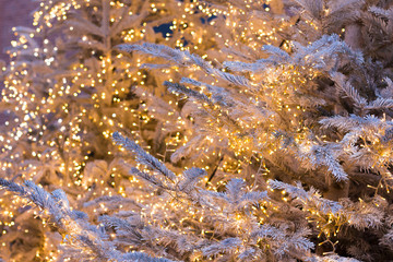 Obraz na płótnie Canvas Silver Christmas tree with golden shining garlands, Christmas background