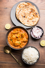 Murgh Makhani / Butter chicken tikka masala served with roti / Paratha and plain rice along with onion salad. selective focus