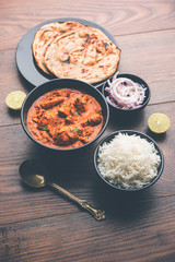 Murgh Makhani / Butter chicken tikka masala served with roti / Paratha and plain rice along with onion salad. selective focus