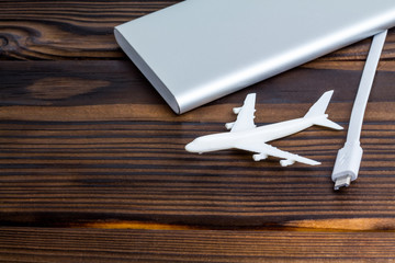 Plane and battery on dark wooden background. Electric plane or green plane concept.