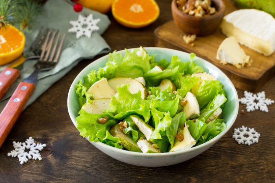 Pear Salad, Walnut, Camembert Cheese and Vinaigrette Dressing on a festive Christmas table.Traditional french cuisine.