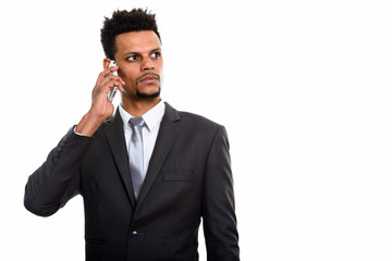 Young African businessman talking on mobile phone while thinking