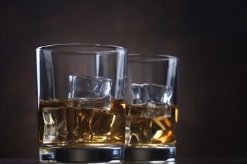 Glasses with whiskey and ice cubes