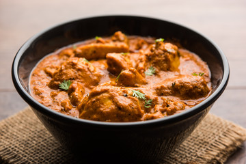 Murgh Makhani / Butter chicken tikka masala served with roti / Paratha and plain rice along with onion salad. selective focus
