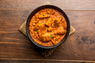 Murgh Makhani / Butter chicken tikka masala served with roti / Paratha and plain rice along with onion salad. selective focus