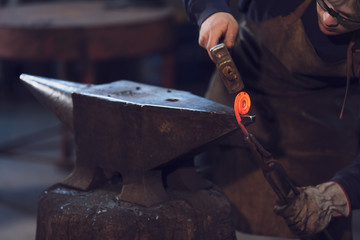 Metalworker forming a coil with hot metal