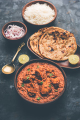 Murgh Makhani / Butter chicken tikka masala served with roti / Paratha and plain rice along with onion salad. selective focus