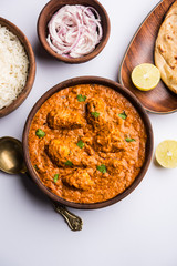 Murgh Makhani / Butter chicken tikka masala served with roti / Paratha and plain rice along with onion salad. selective focus
