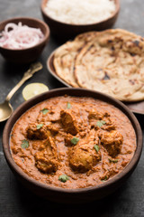 Murgh Makhani / Butter chicken tikka masala served with roti / Paratha and plain rice along with onion salad. selective focus