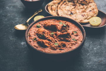 Murgh Makhani / Butter chicken tikka masala served with roti / Paratha and plain rice along with onion salad. selective focus