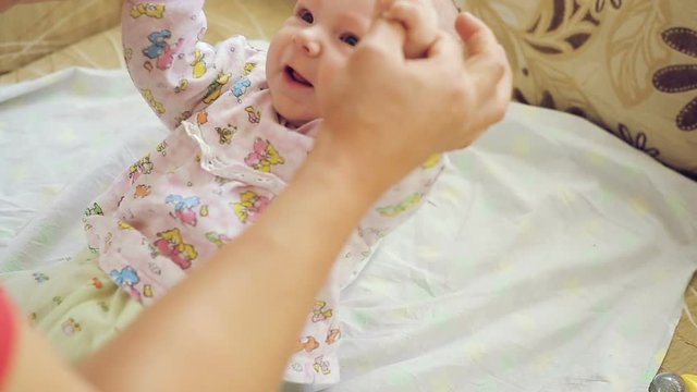 Dad makes charging the newborn, the child bends the arms