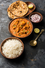 Murgh Makhani / Butter chicken tikka masala served with roti / Paratha and plain rice along with onion salad. selective focus