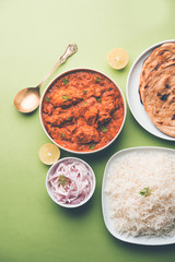 Murgh Makhani / Butter chicken tikka masala served with roti / Paratha and plain rice along with onion salad. selective focus