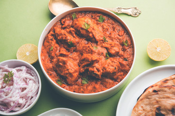 Murgh Makhani / Butter chicken tikka masala served with roti / Paratha and plain rice along with onion salad. selective focus