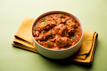 Murgh Makhani / Butter chicken tikka masala served with roti / Paratha and plain rice along with onion salad. selective focus
