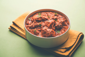 Murgh Makhani / Butter chicken tikka masala served with roti / Paratha and plain rice along with onion salad. selective focus