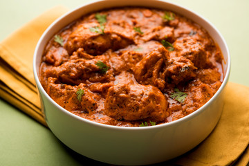 Murgh Makhani / Butter chicken tikka masala served with roti / Paratha and plain rice along with onion salad. selective focus