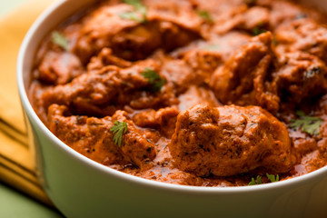 Murgh Makhani / Butter chicken tikka masala served with roti / Paratha and plain rice along with onion salad. selective focus