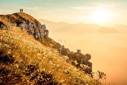 hikers walking at sunrise on top of italian alps mountains - weekend activities vacation and sport concept with adventure people - Warm bright sunshine filter