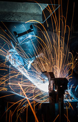 worker with protective mask welding metal