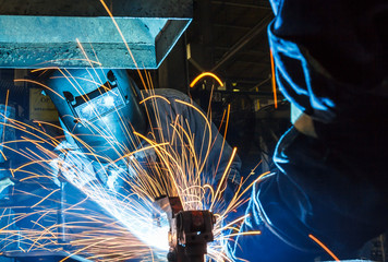 worker with protective mask welding metal