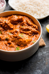 Murgh Makhani / Butter chicken tikka masala served with roti / Paratha and plain rice along with onion salad. selective focus