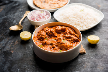 Murgh Makhani / Butter chicken tikka masala served with roti / Paratha and plain rice along with onion salad. selective focus