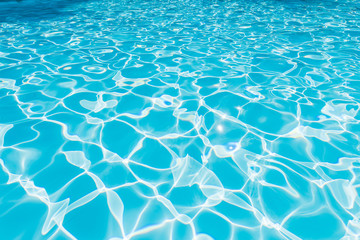 Pattern of blue water surface in swimming pool, Ripple wave and motion water for blue background and abstract, Bright and purified water with sun reflection in pool