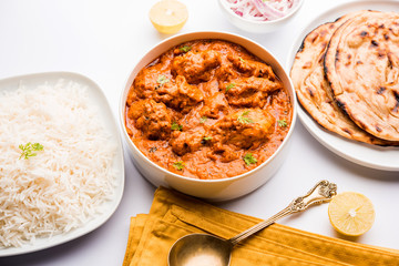 Murgh Makhani / Butter chicken tikka masala served with roti / Paratha and plain rice along with onion salad. selective focus