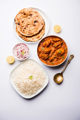 Murgh Makhani / Butter chicken tikka masala served with roti / Paratha and plain rice along with onion salad. selective focus