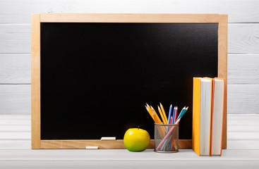 Little blackboard and school supplies on  background