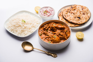 Murgh Makhani / Butter chicken tikka masala served with roti / Paratha and plain rice along with onion salad. selective focus