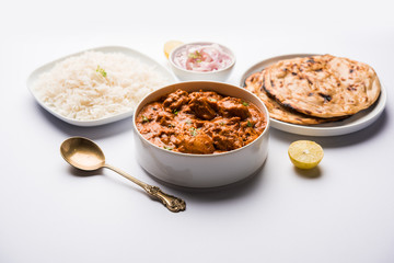 Murgh Makhani / Butter chicken tikka masala served with roti / Paratha and plain rice along with onion salad. selective focus